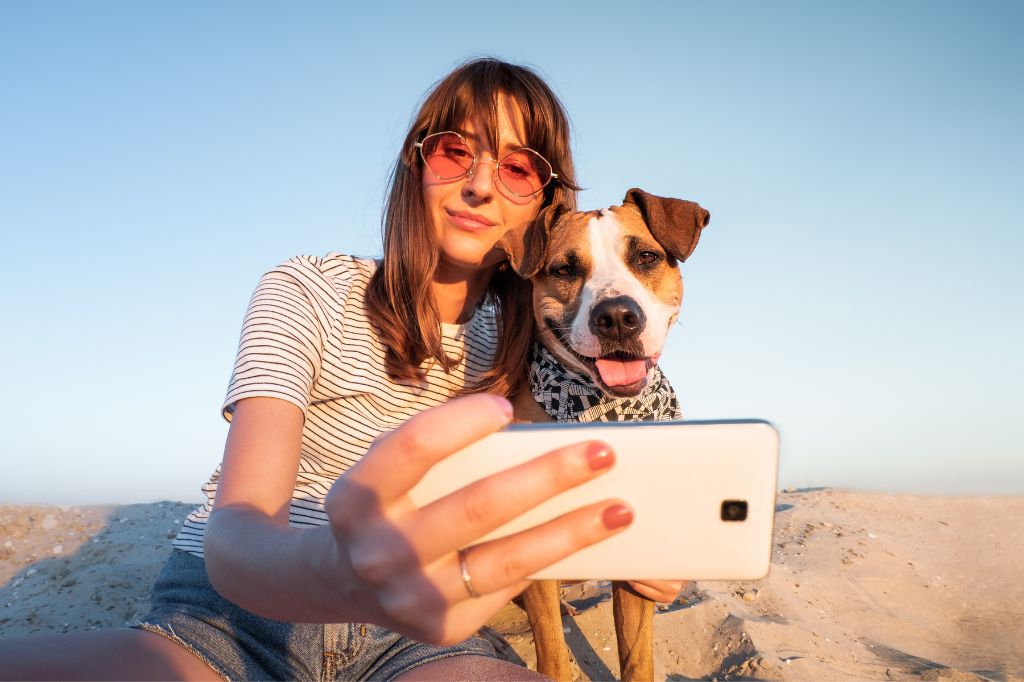 Chica con perro tomándose selfie
