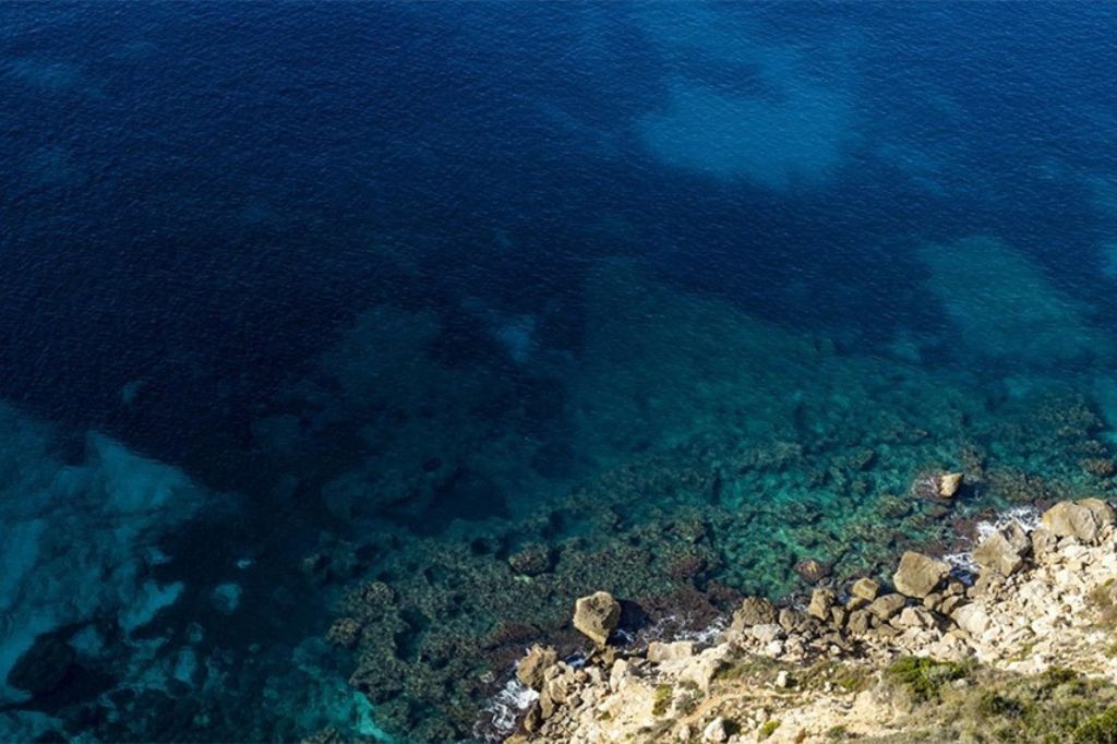 Mar azul claro y acantilados en Badia Grande