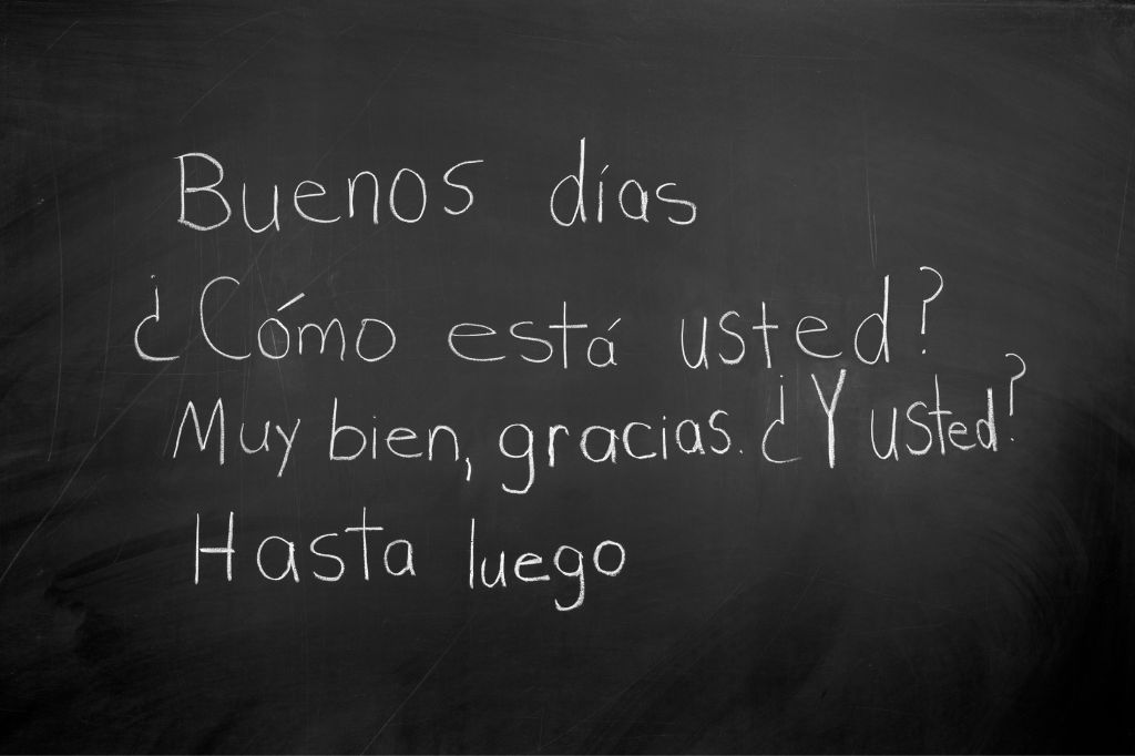 Frases en español escritas con tiza en una pizarra escolar